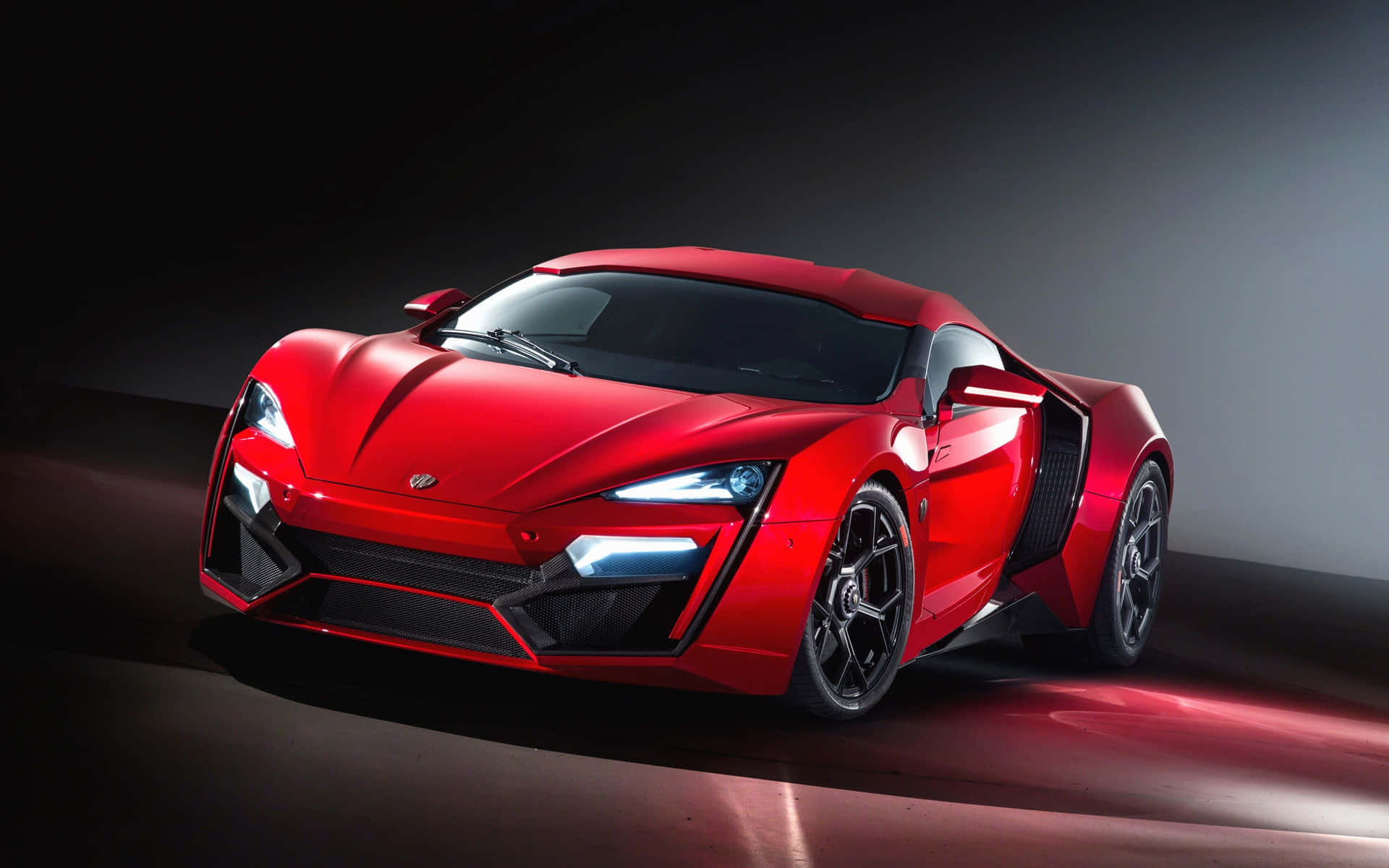 A Red Sports Car Is Shown In A Dark Room Wallpaper