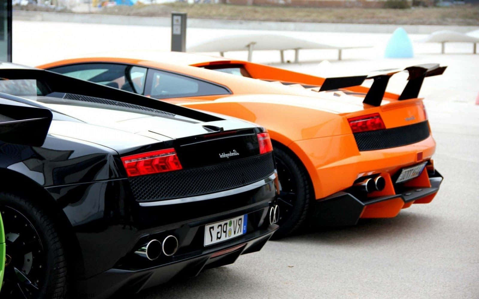 Two Lamborghinis Parked Next To Each Other Wallpaper