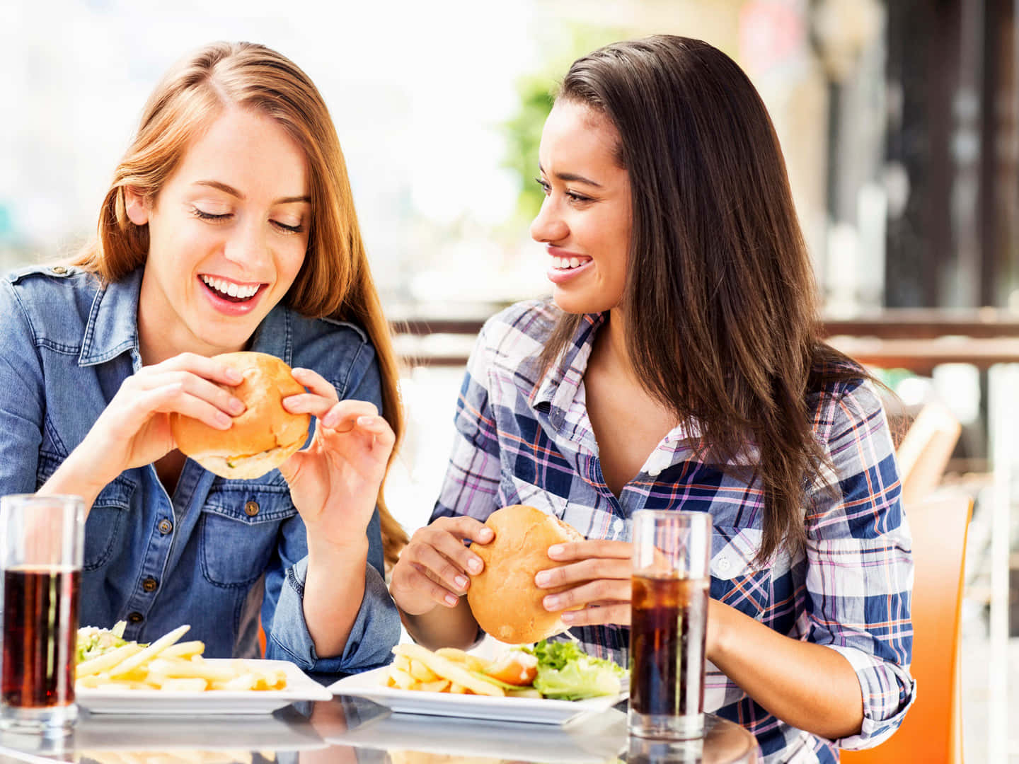Tvåkvinnor Äter Hamburgare Och Pommes Frites På En Restaurang