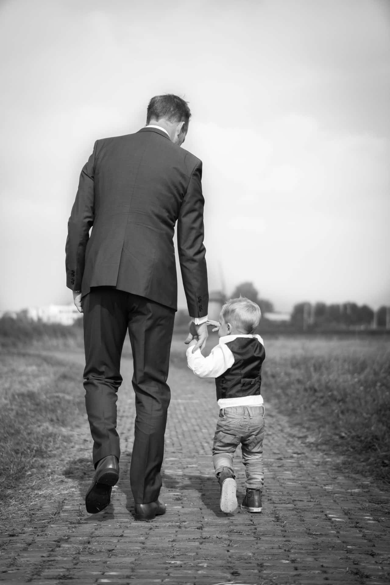 A Man In A Suit Walking With A Child
