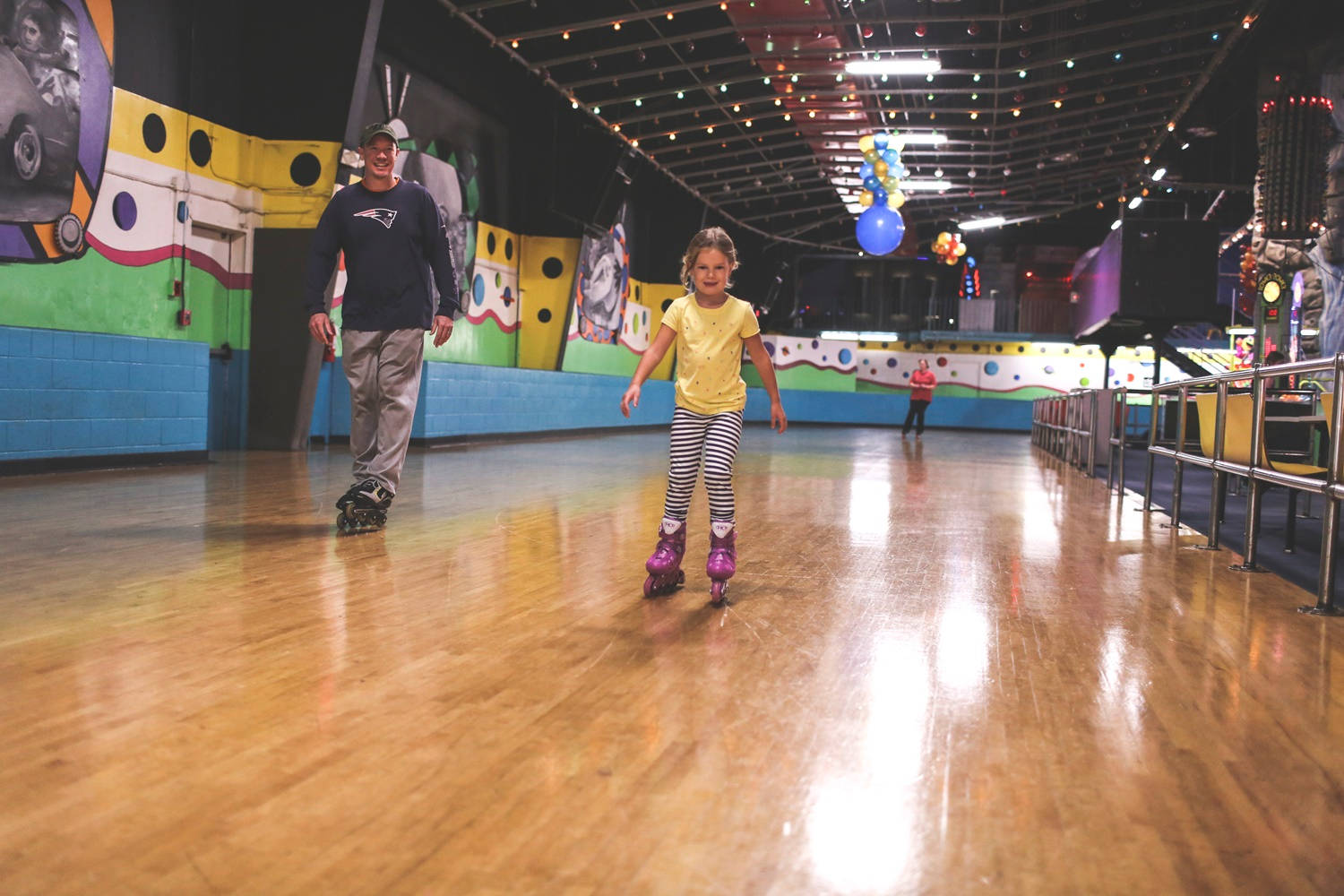 Father And Daughter Indoor Rollerblading Wallpaper