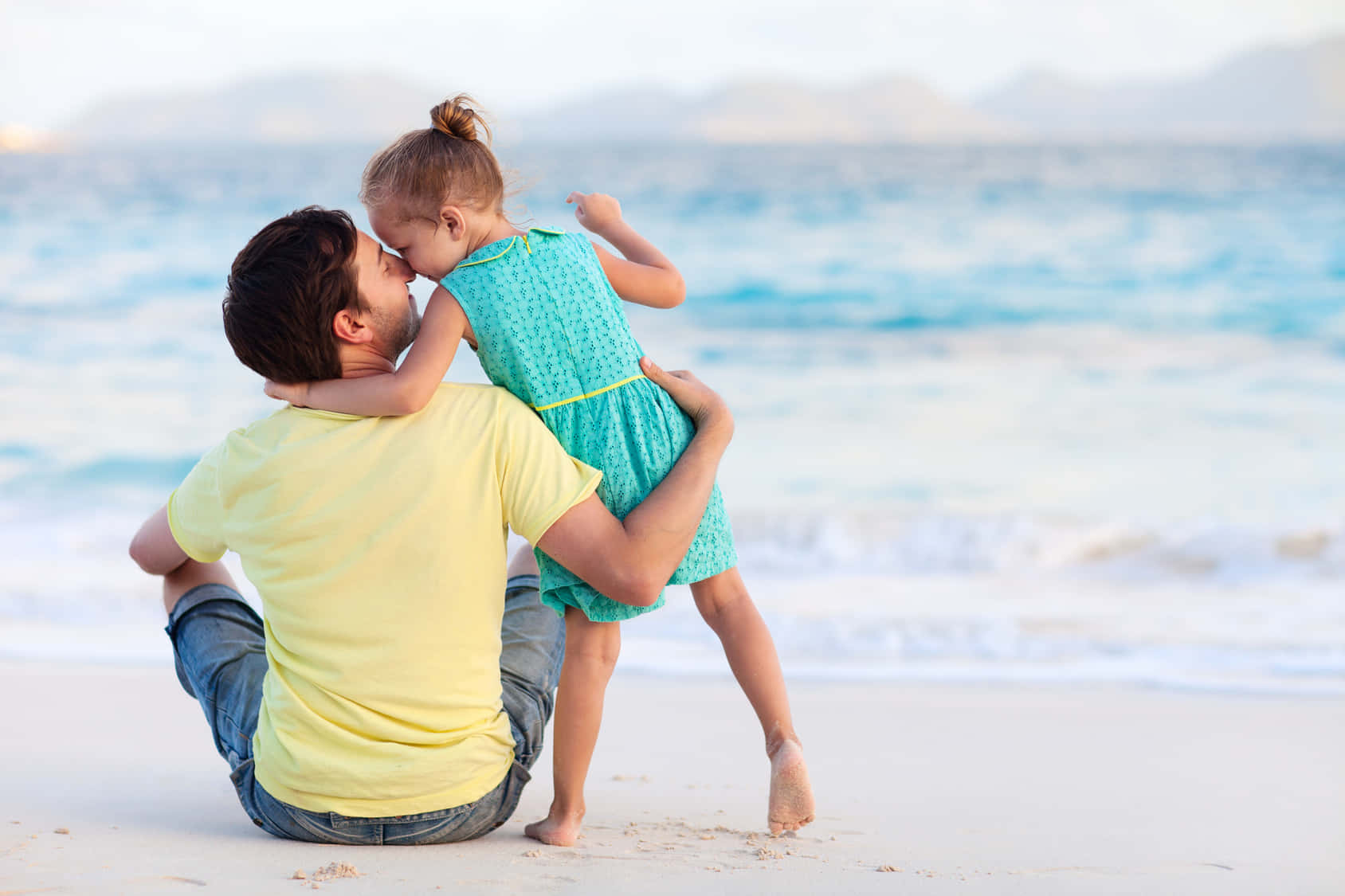 Fader og datter kysse på strandbillede