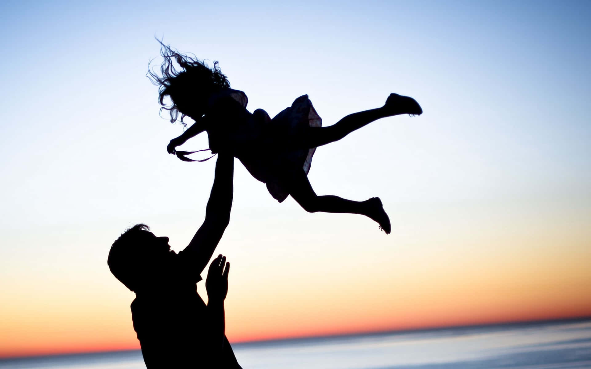 Far og datter kaster sig i luften billedtapet