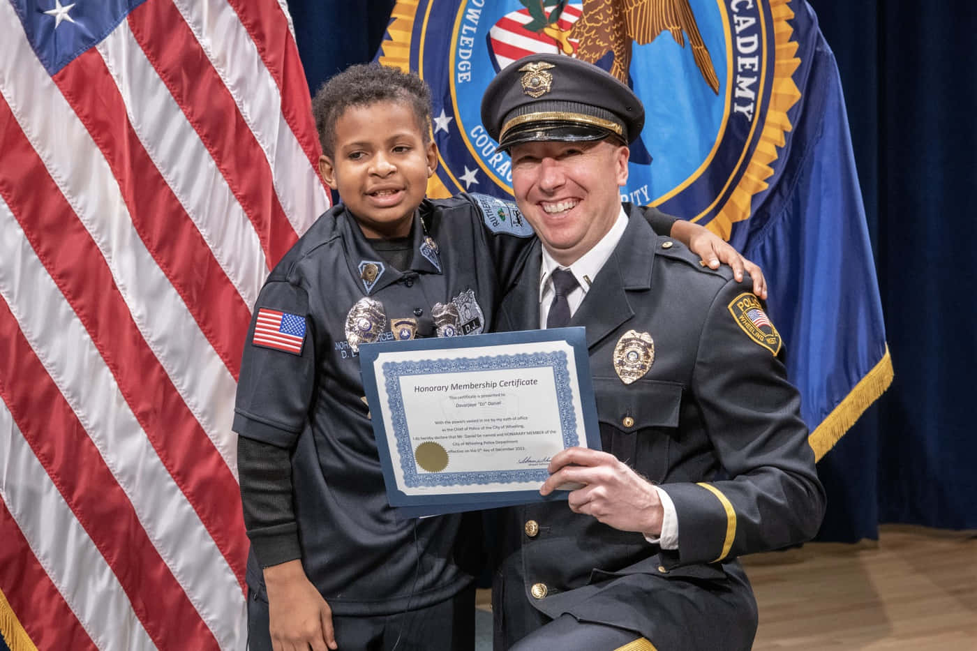 En politibetjent giver et certifikat til en ung dreng. Wallpaper