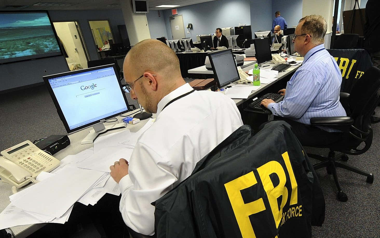 Fbi Agents Working In An Office With Computers