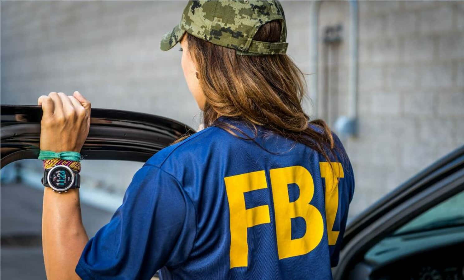 Fbi Officer In A Camouflage Shirt Leaning Out Of A Car