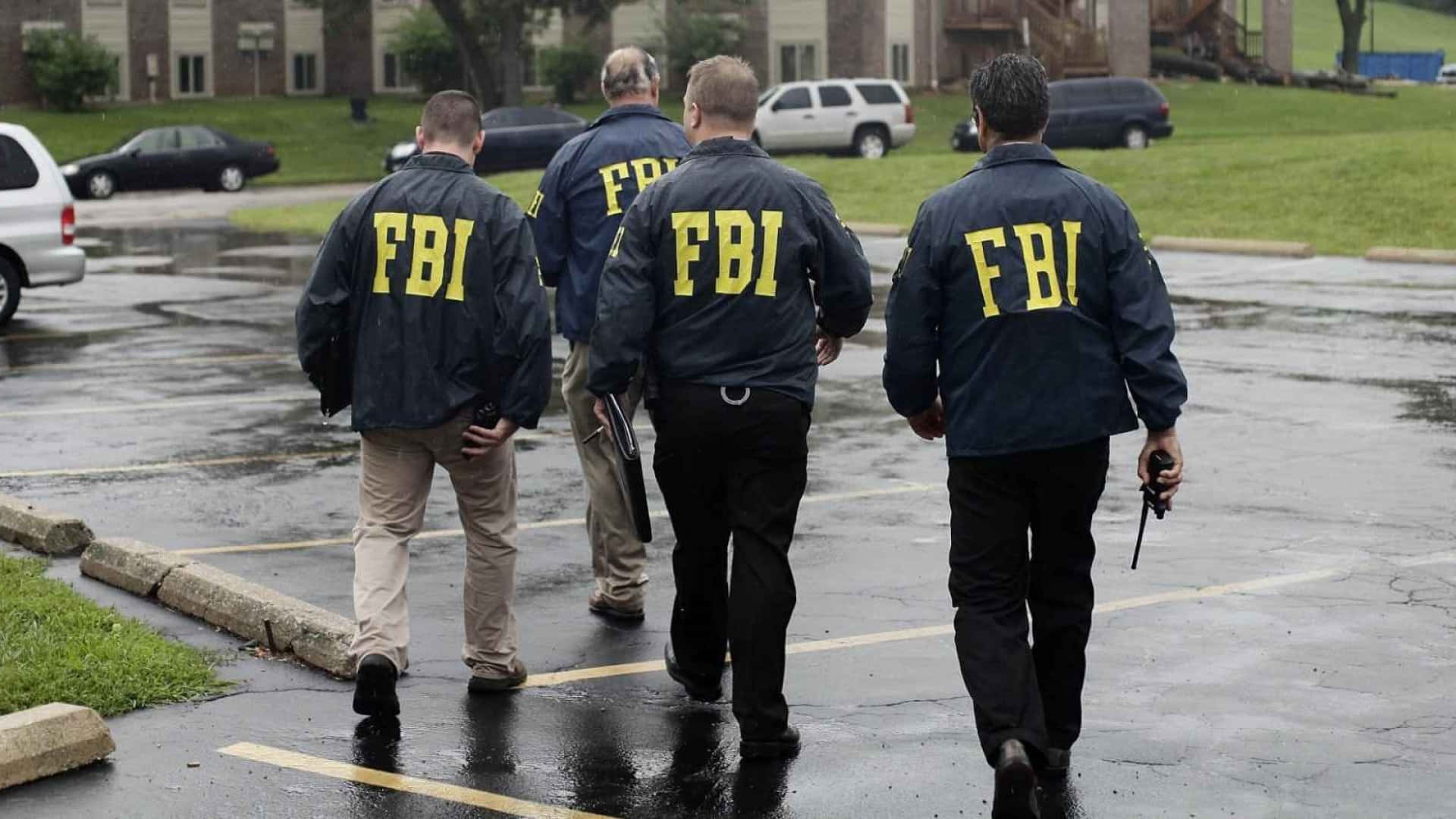 Tre FBI-agenter, der går i regnen. Wallpaper