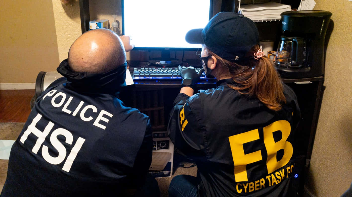 Two Fbi Agents Looking At A Computer Wallpaper