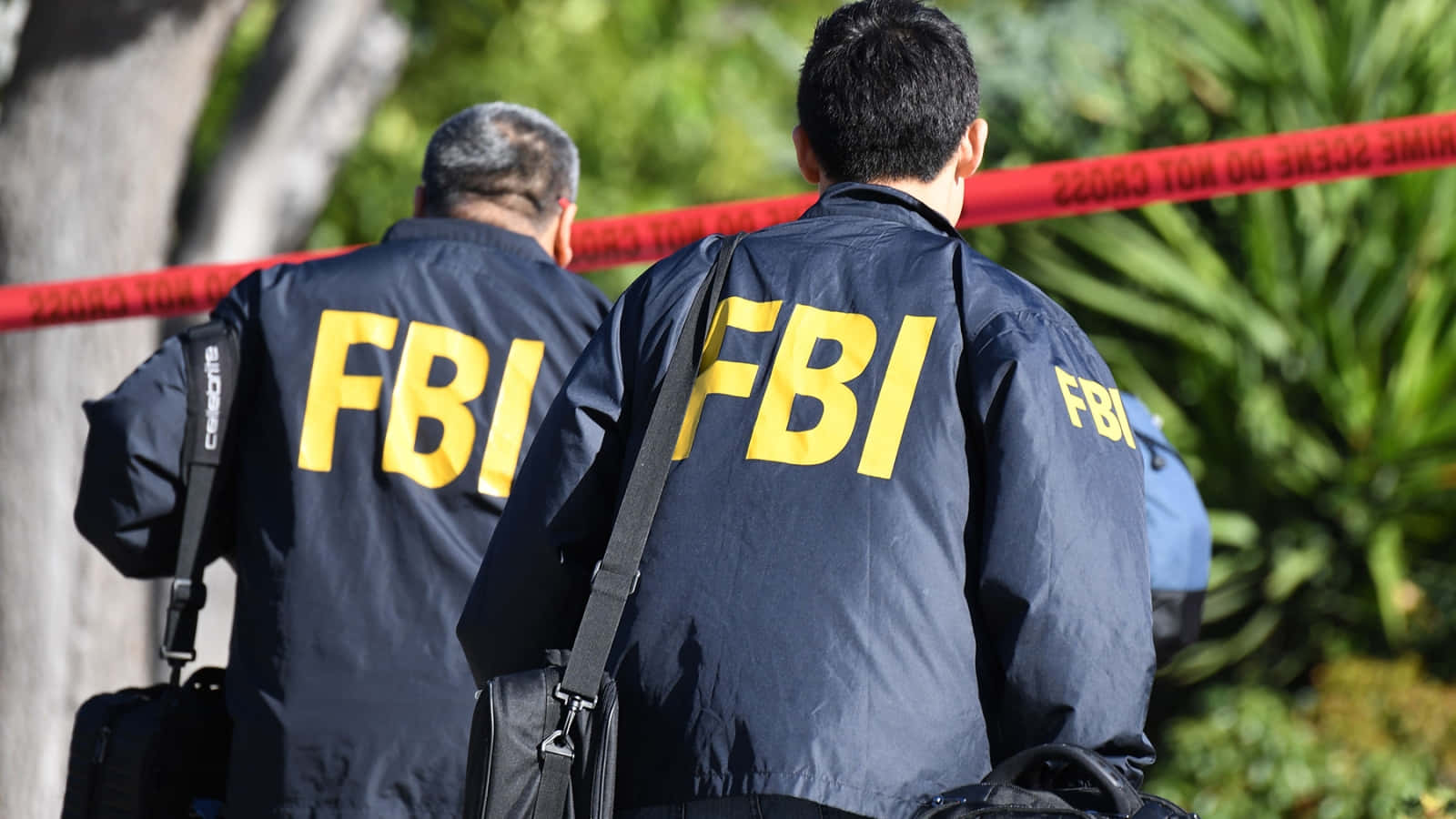 To mænd i FBI-jakker går ned ad gaden Wallpaper