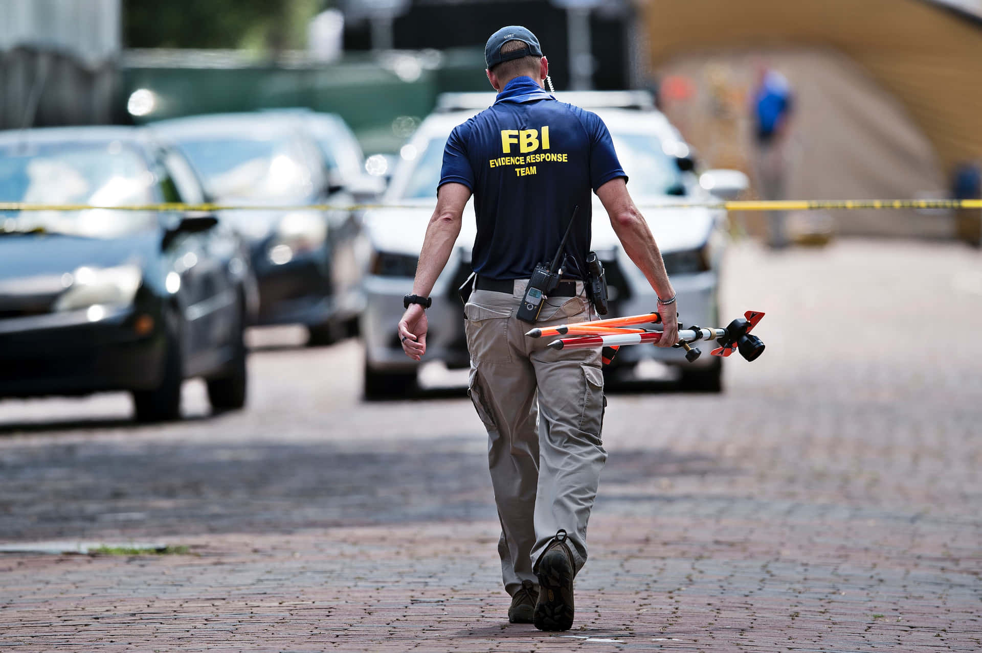 En FBI-agent går ned ad en gade med en drone over sig. Wallpaper