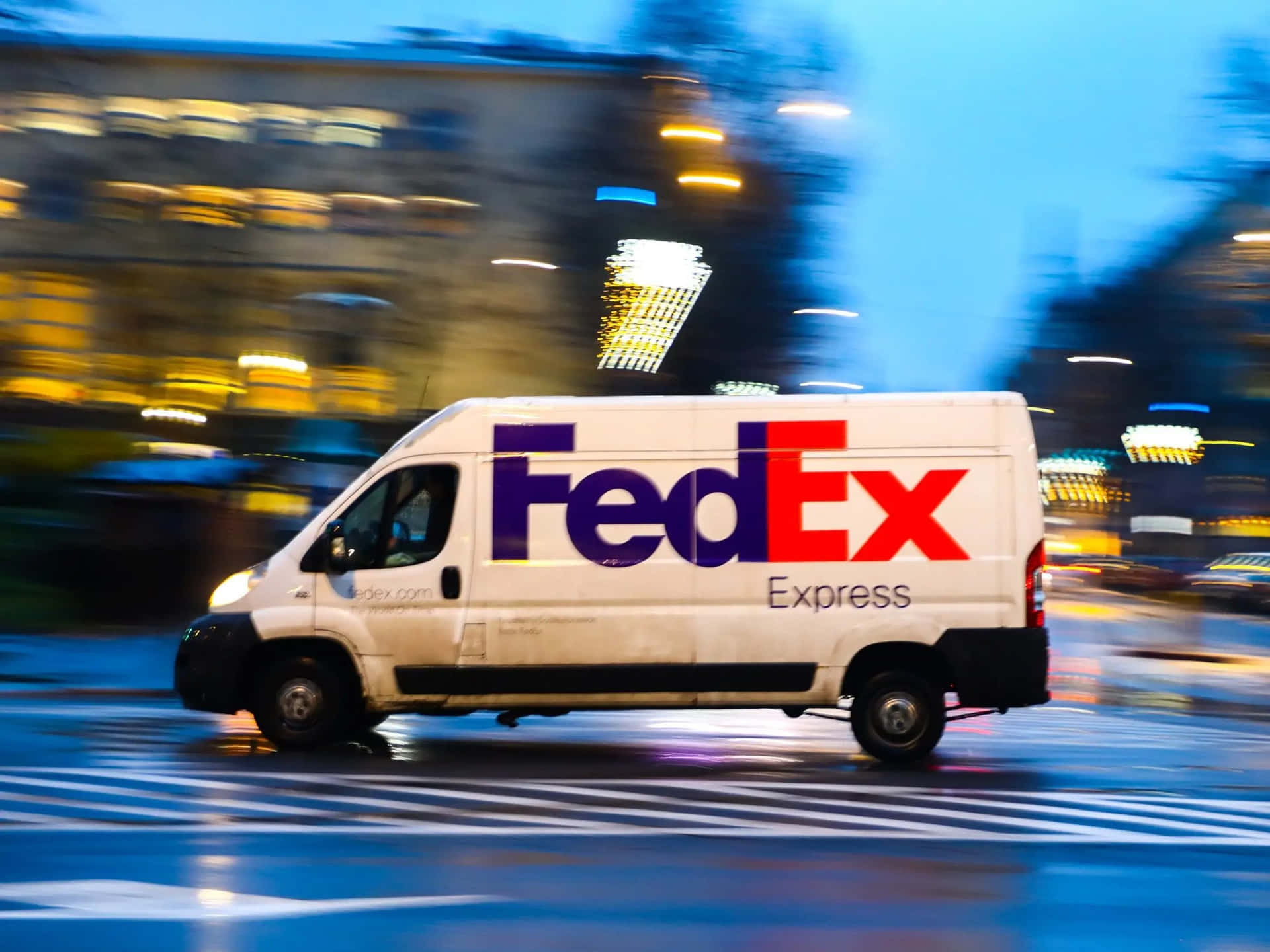 Fedex Express Van Driving Down The Street At Night