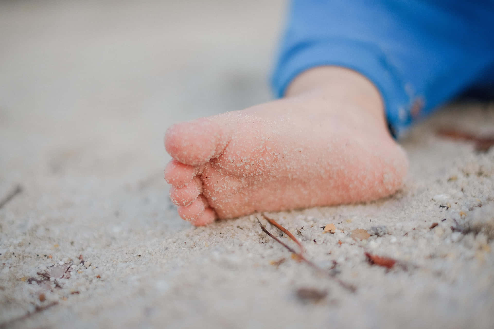 A Child's Foot Laying In The Sand