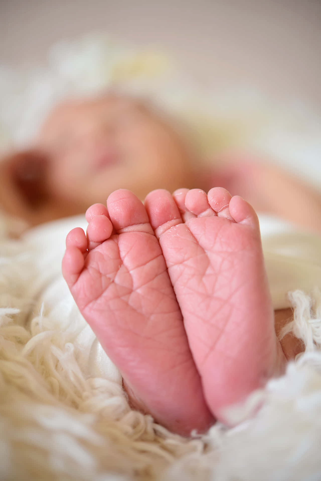A Newborn Baby's Feet Are Laying On A White Blanket