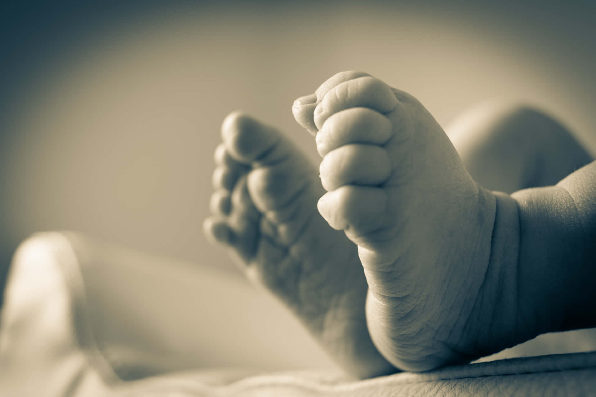 A Baby's Feet Are Shown On A Bed