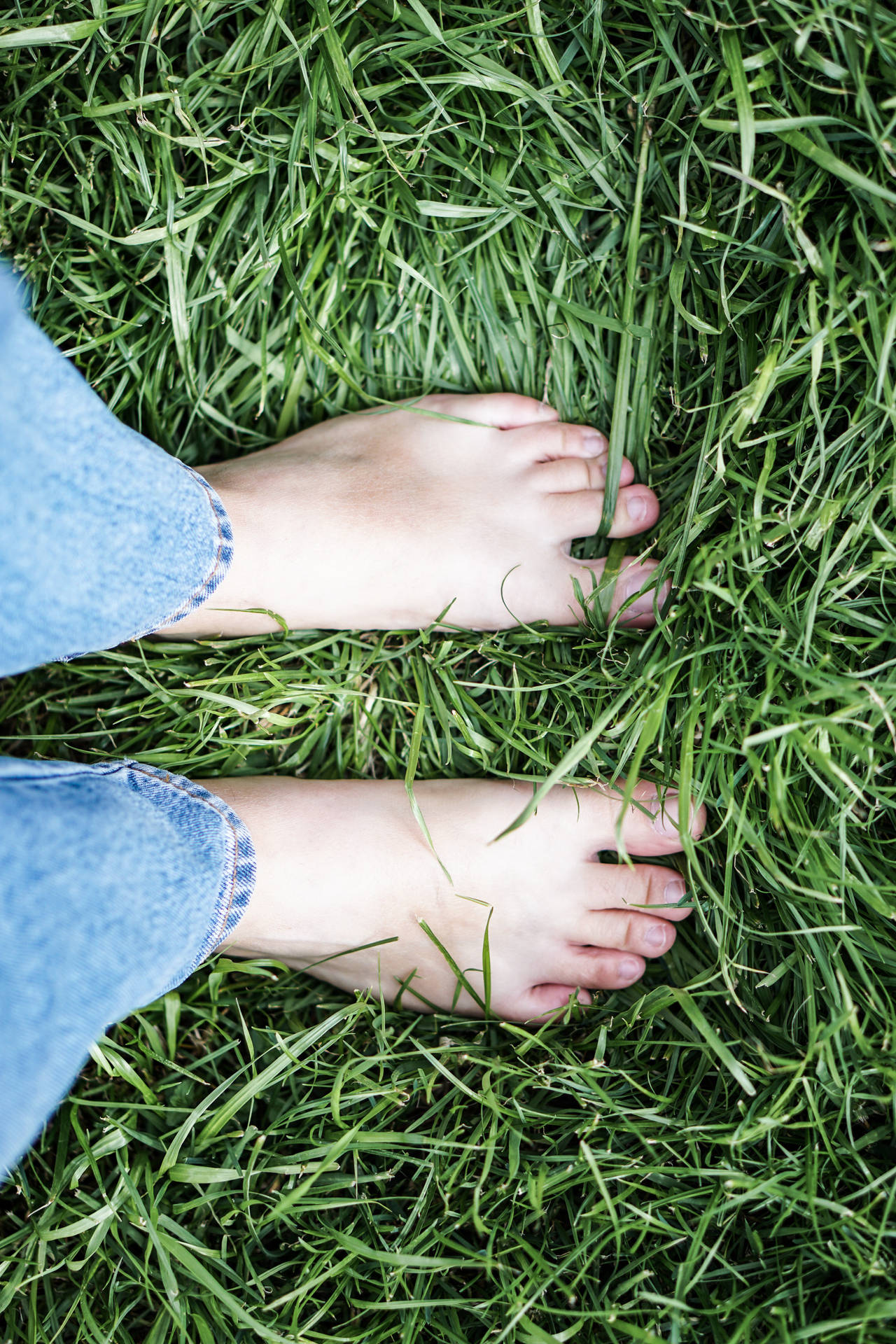 Feet Standing On Thick Grass Wallpaper
