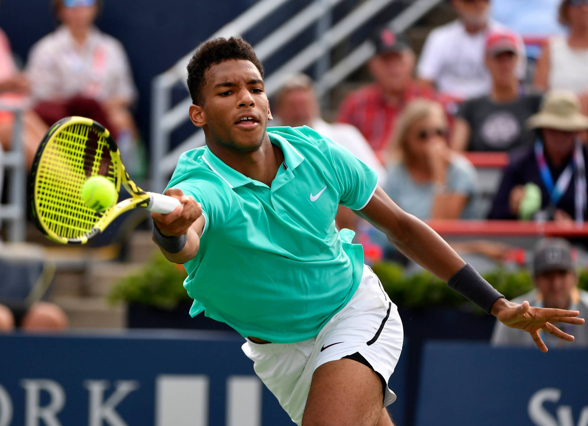 Professional Tennis Player Felix Auger-Aliassime Concentrated on Chasing the Ball Wallpaper