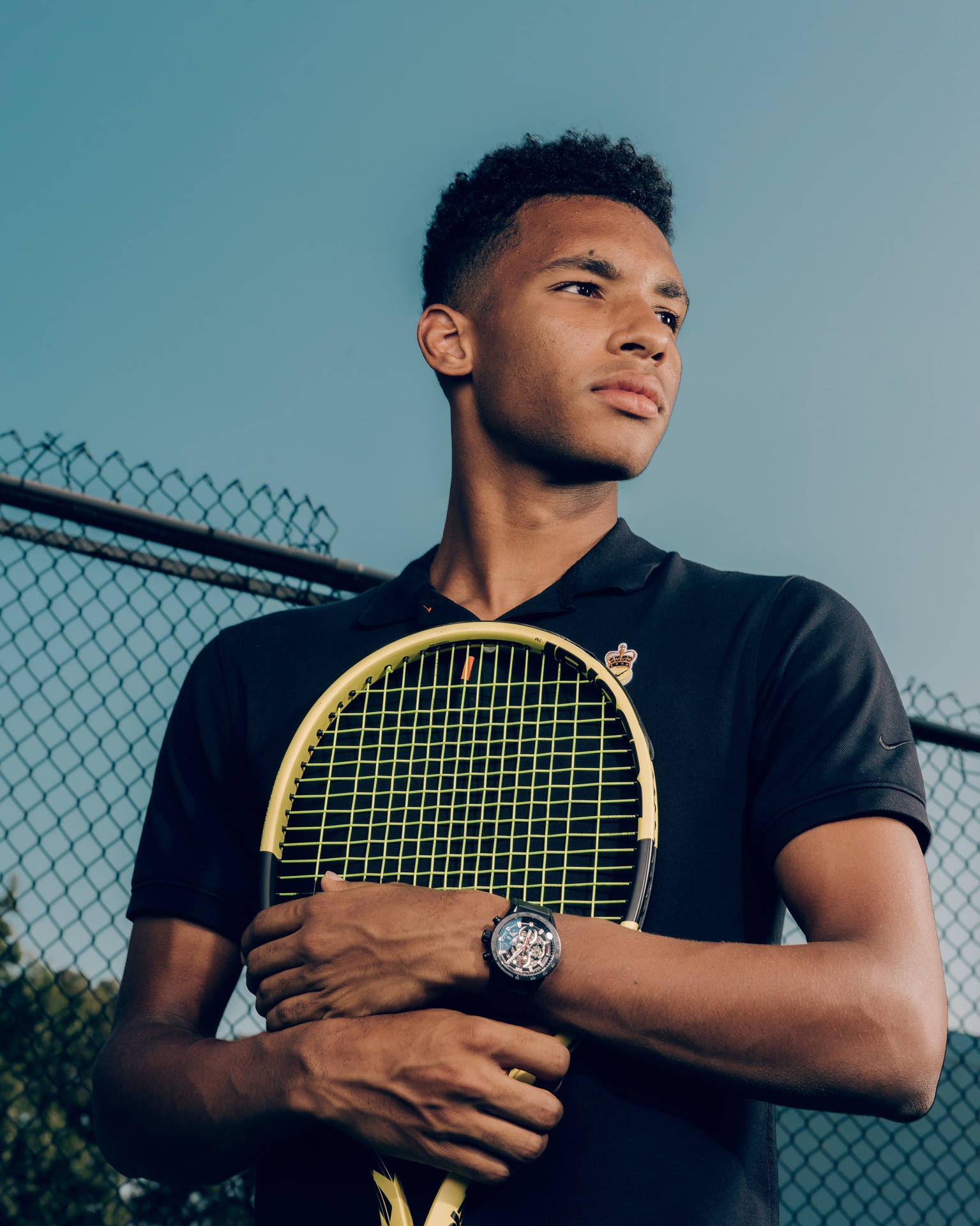 Felix Auger Aliassime in an intense moment, embracing his racket on court. Wallpaper