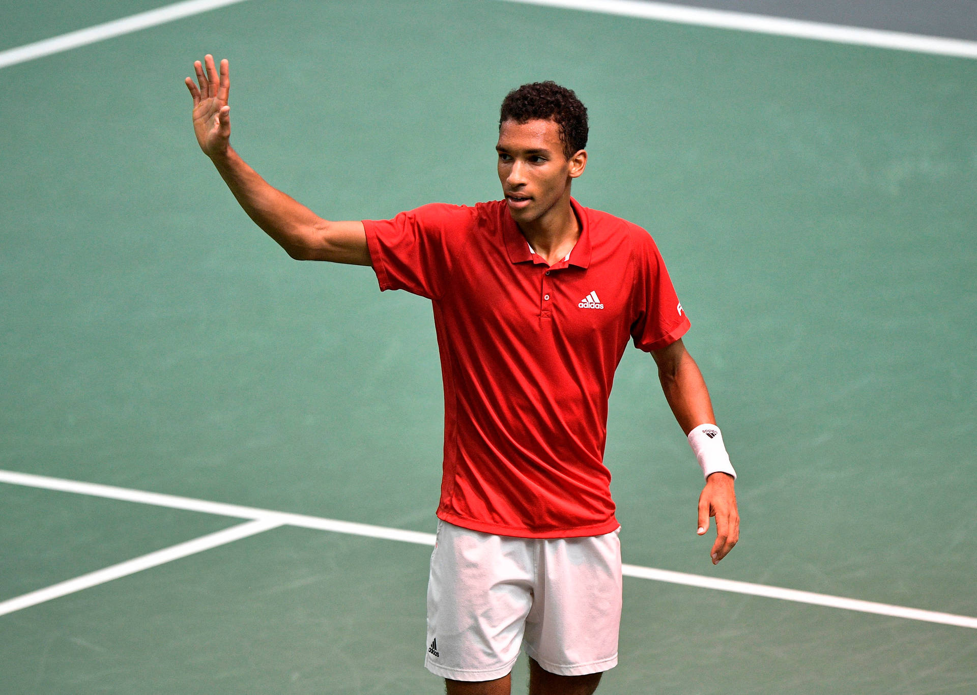 Felix Auger Aliassime Waving To Audience Wallpaper