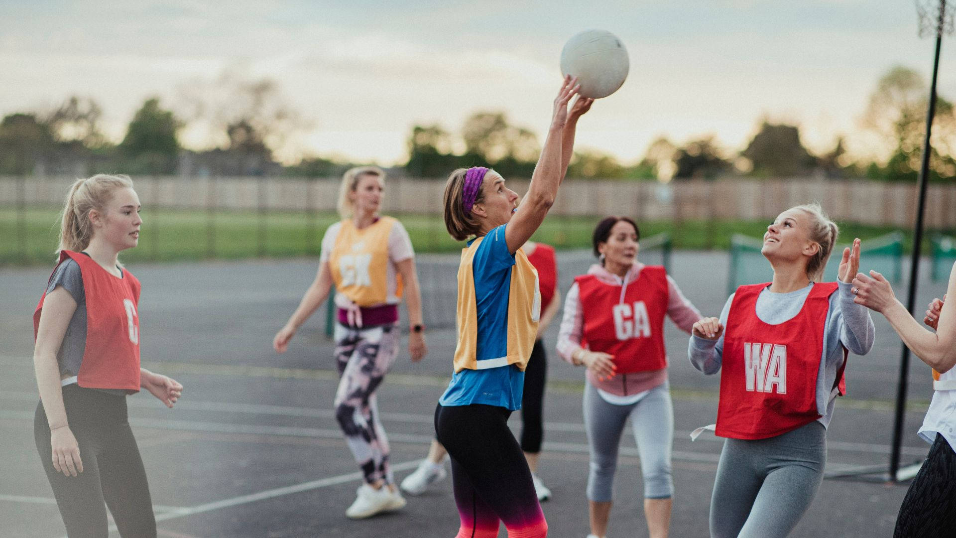 Kvindelige studerende, der spiller netball-skudmål Wallpaper