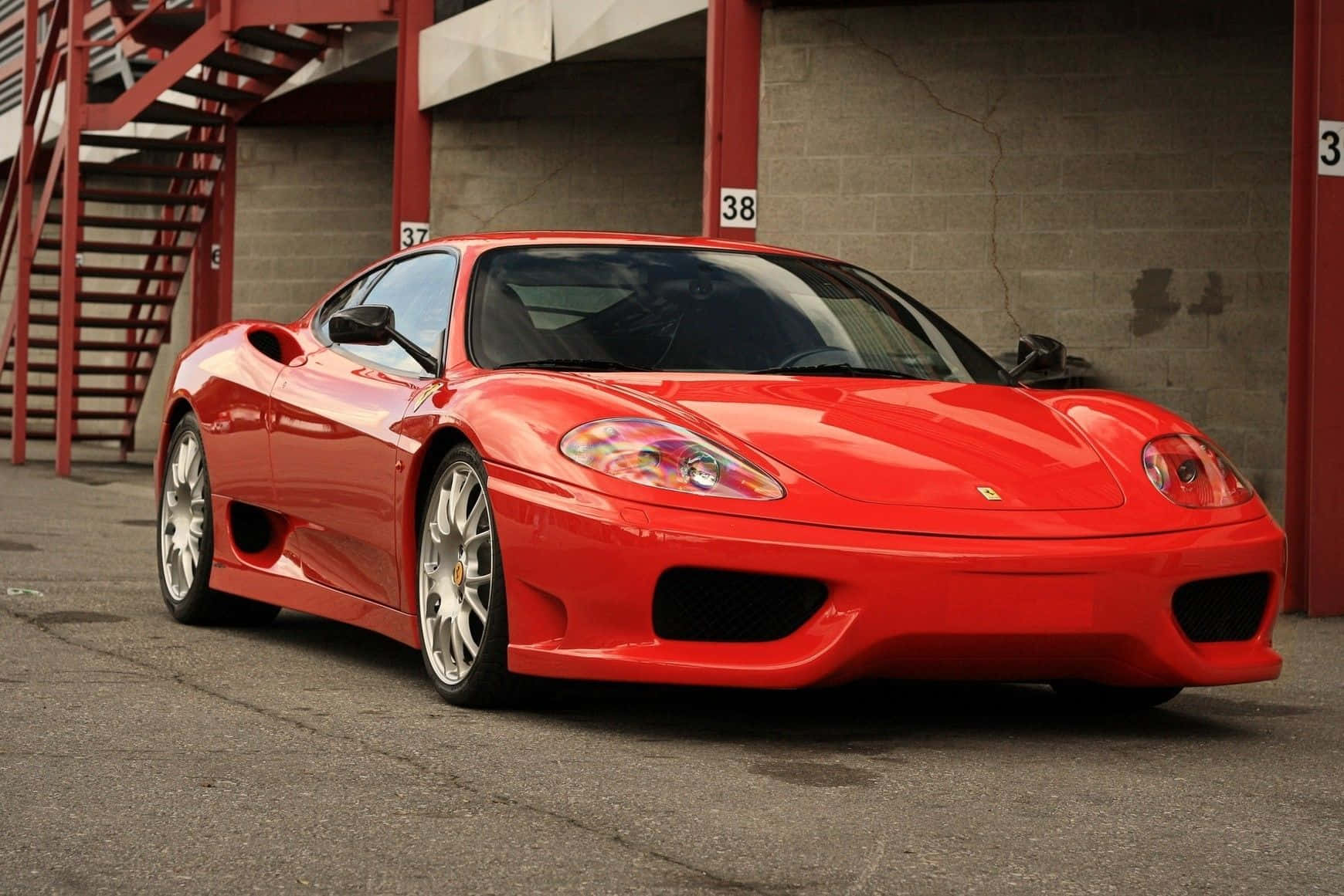 Caption: Red Ferrari 360 Modena Speeding Down the Road Wallpaper