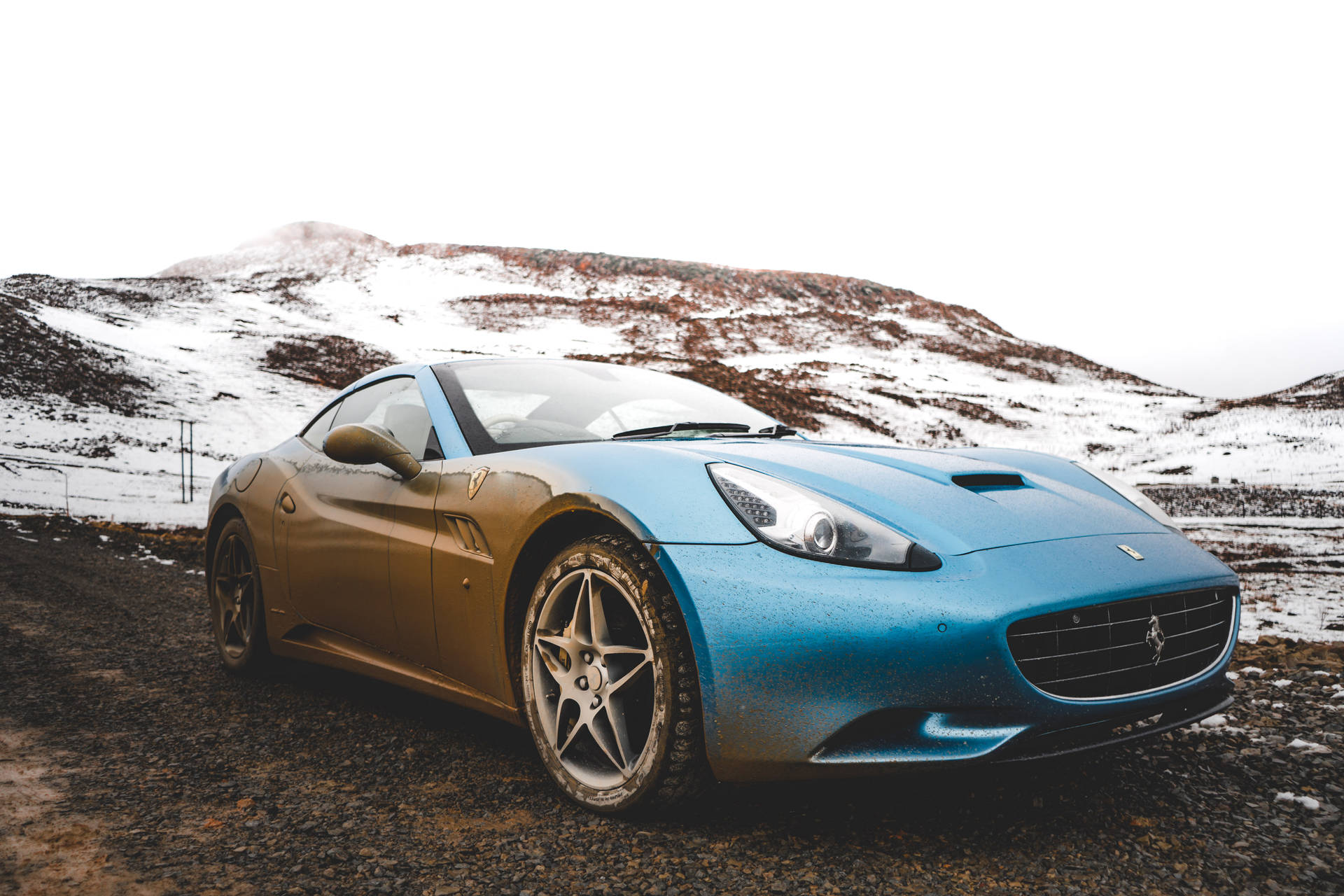 Ferrari California blue parked on snow hill wallpaper.