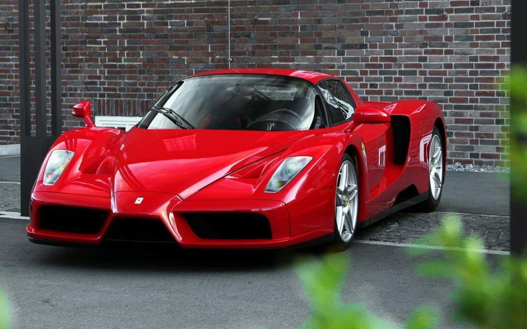 A stunning red Ferrari Enzo showcased in natural light Wallpaper