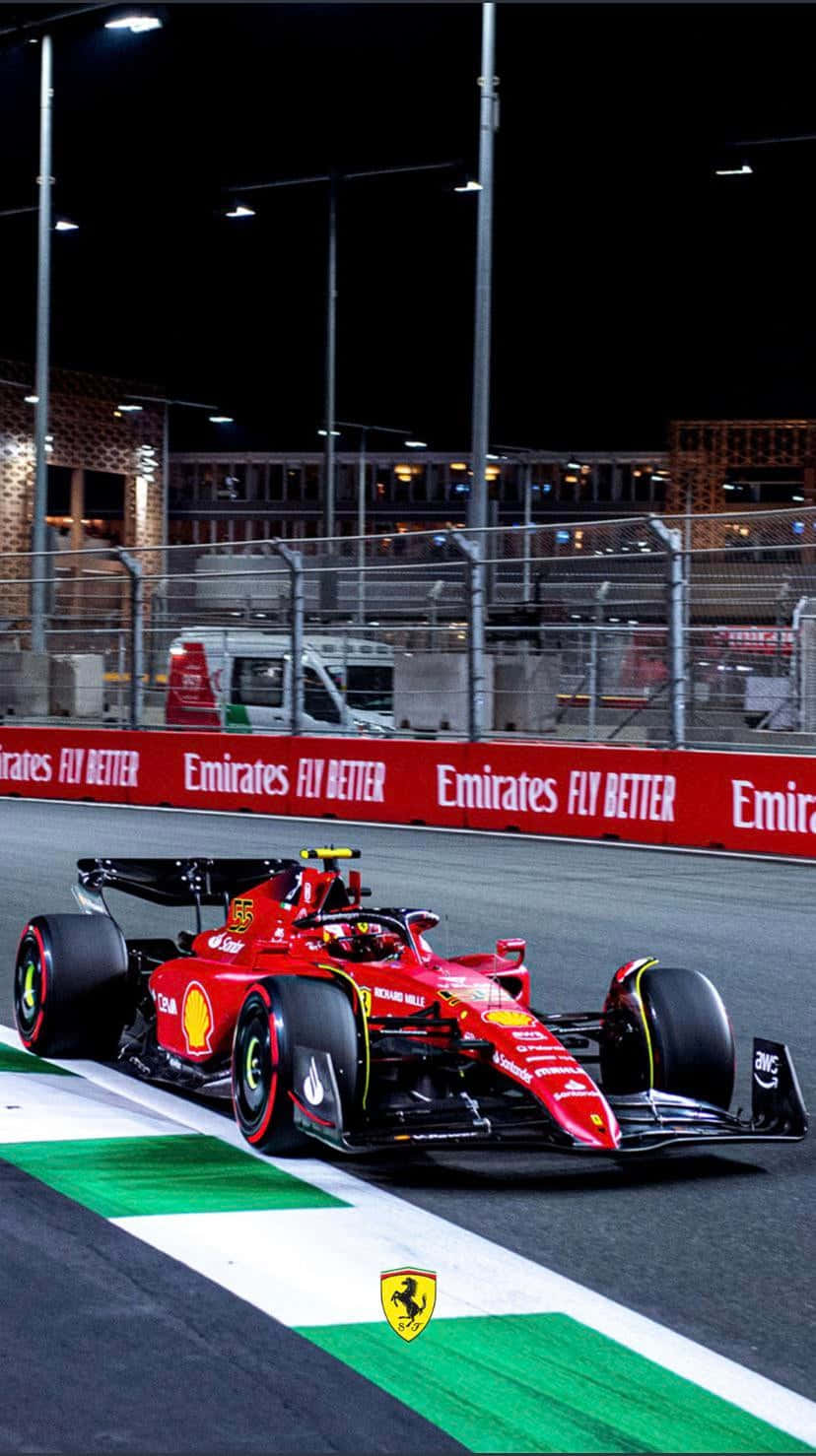 A Ferrari Racing Car Driving On A Track At Night Wallpaper