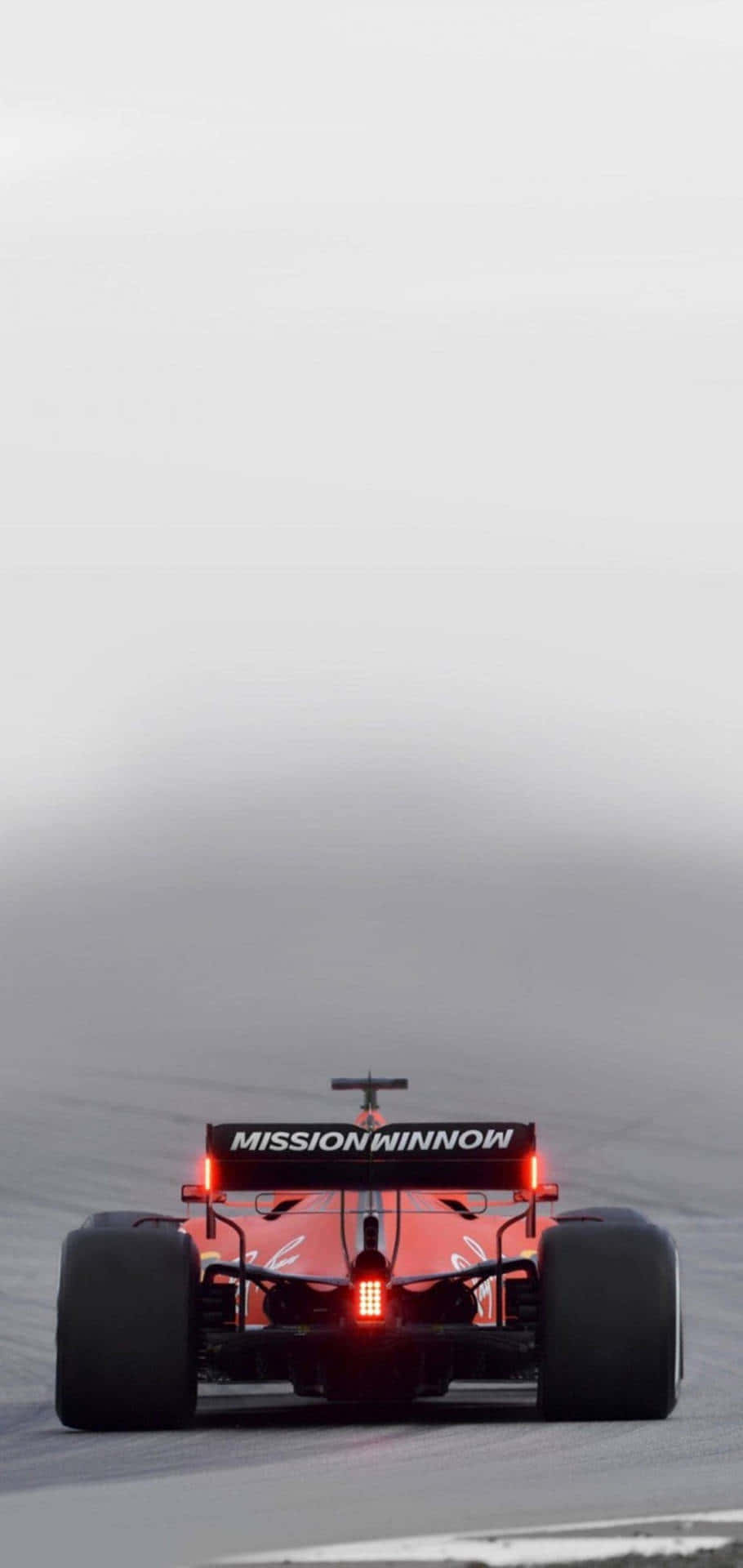 A Red Racing Car Driving On A Track Wallpaper
