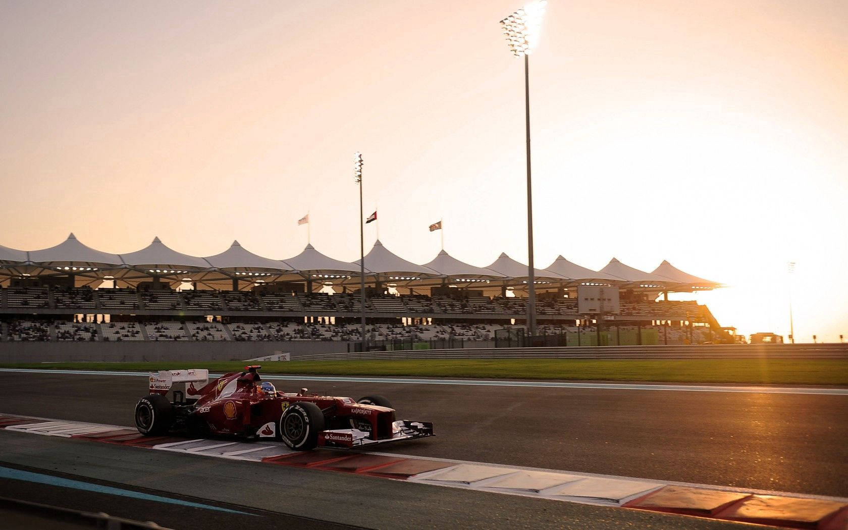 A dynamic view of a Ferrari Formula One car on the track Wallpaper