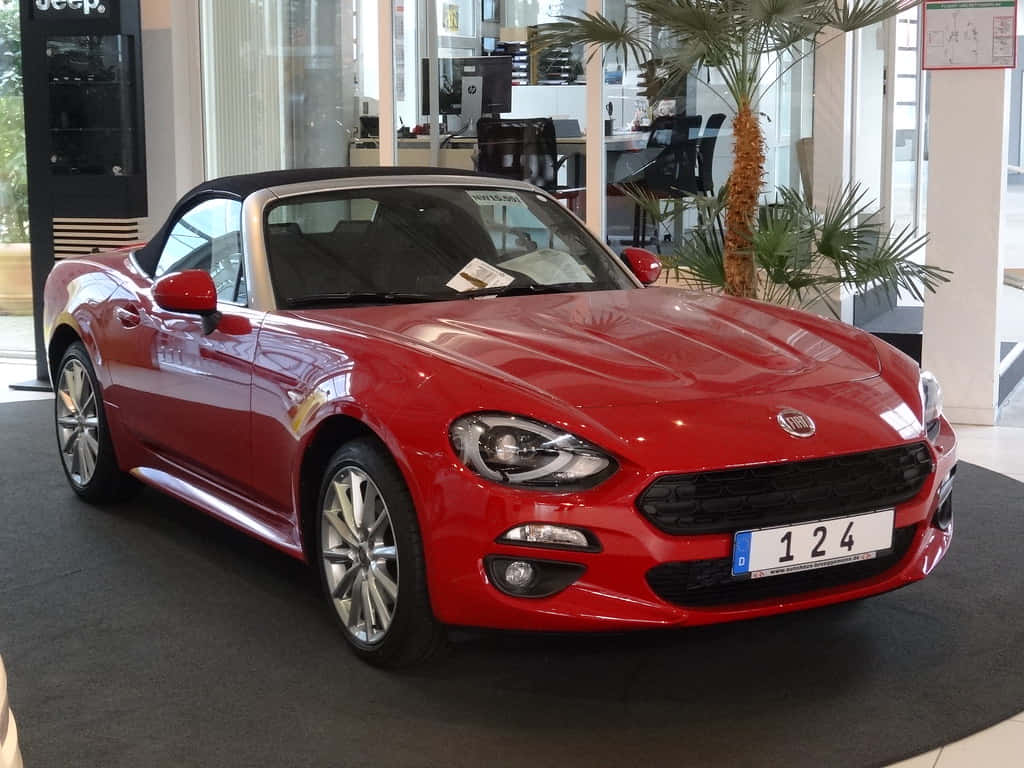 Caption: Sleek White Fiat 124 Spider Cruising on an Open Road Wallpaper