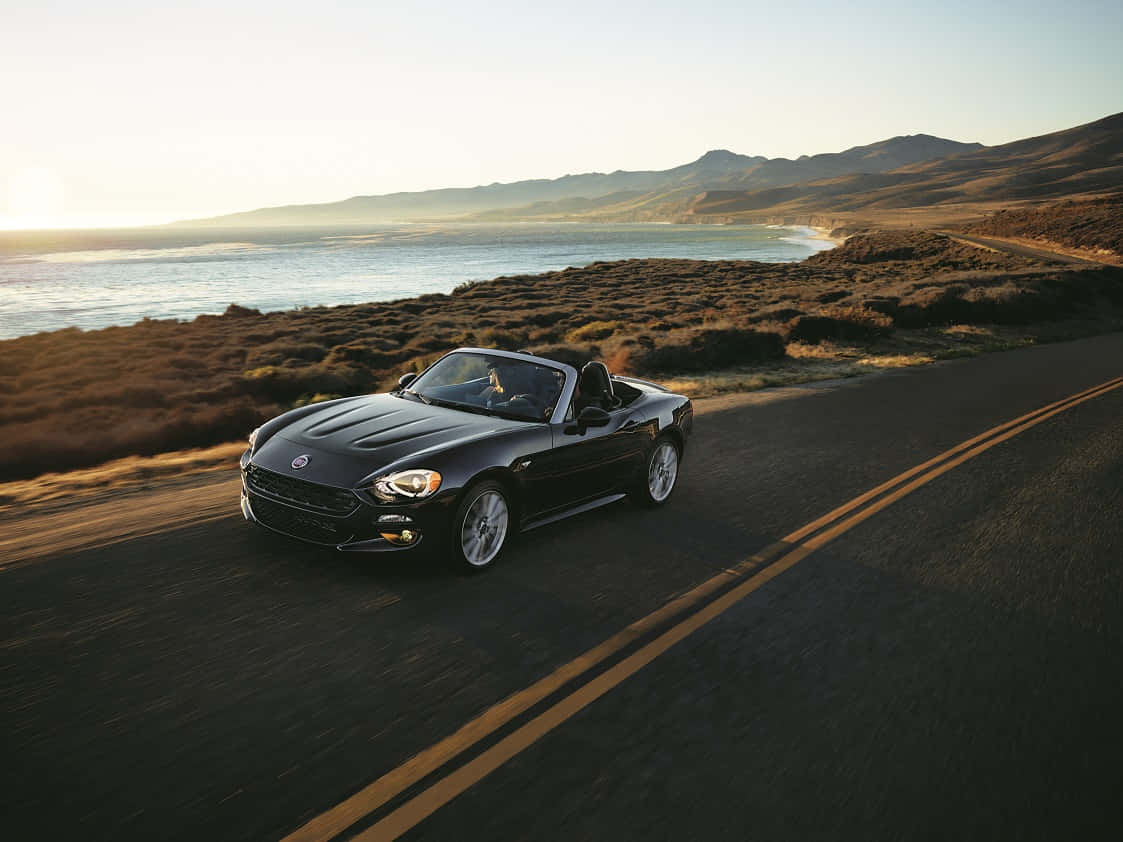 Fiat 124 Spider showcasing its elegant design and dynamic stance Wallpaper