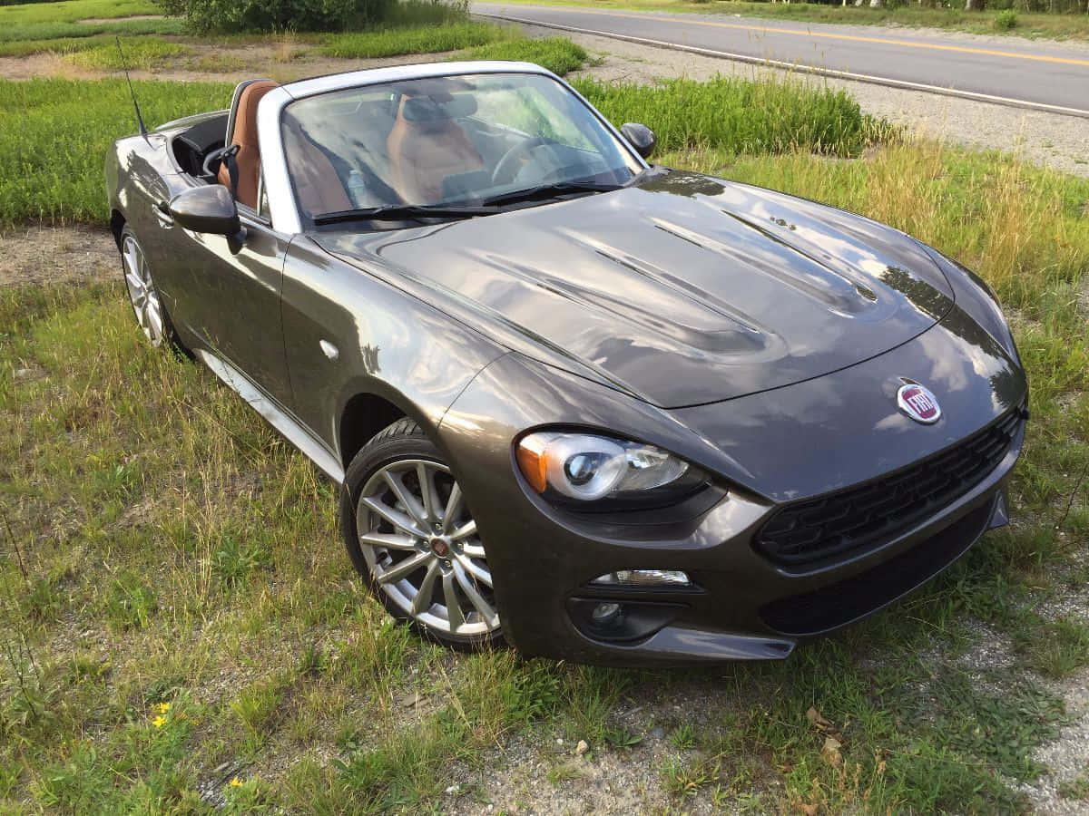 Fiat 124 Spider Convertible on a Scenic Road Wallpaper