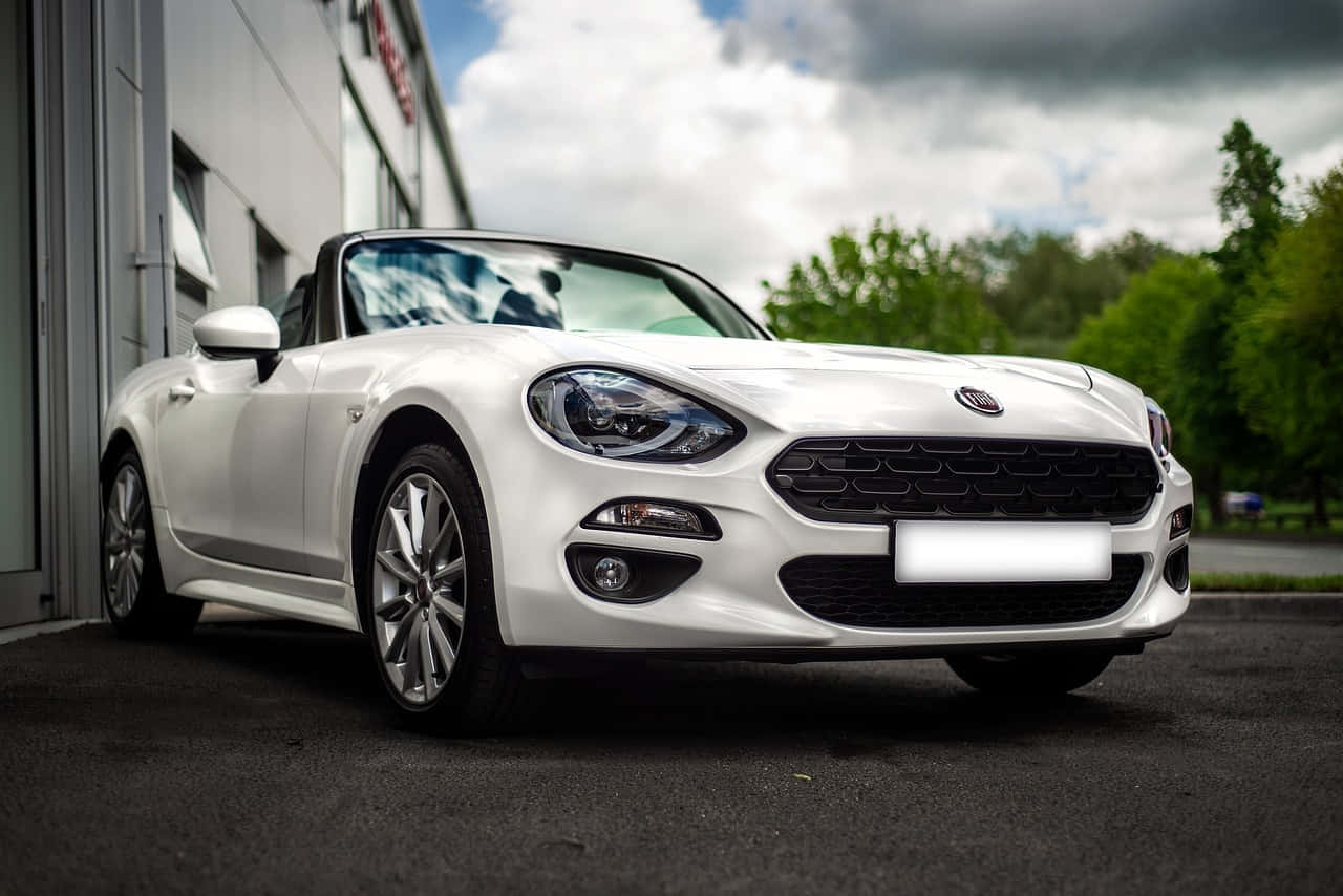 Sleek Fiat 124 Spider convertible sports car in action Wallpaper