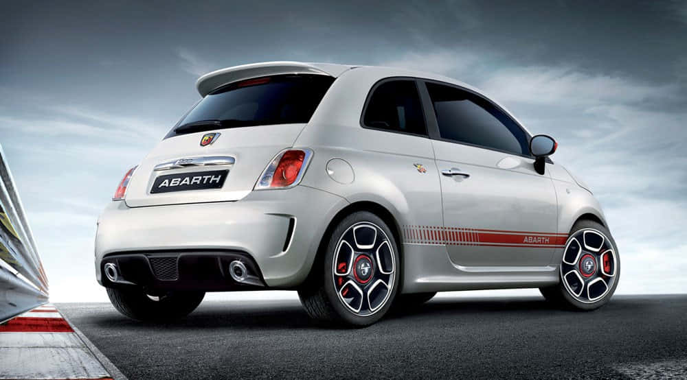 Catch a glimpse of this sleek and stylish Fiat 500 on a picturesque coastline drive. Wallpaper