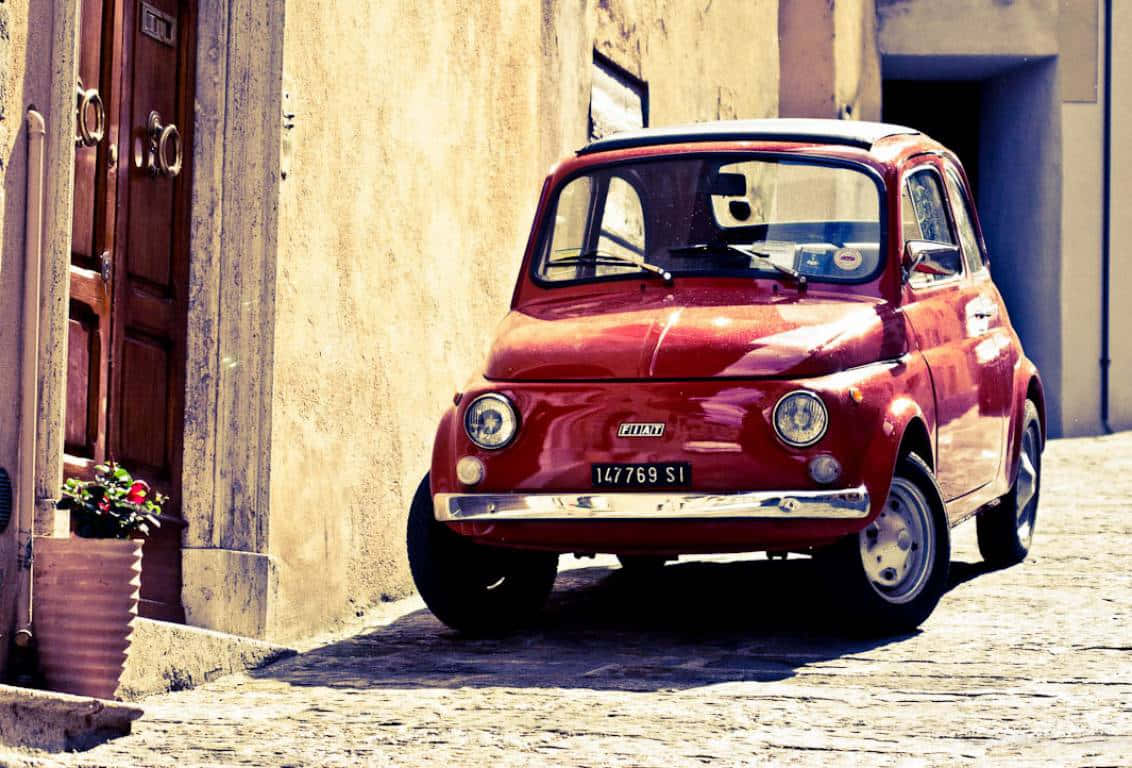 Fiat 500 Classic Car Parked on City Street Wallpaper