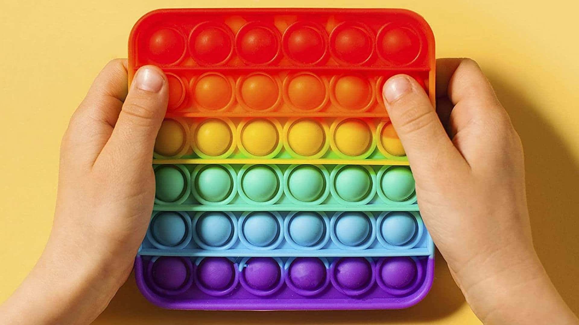 A Person Holding A Tray With Colorful Eggs In It