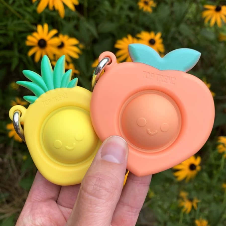 A Person Holding Two Fruit Shaped Silicone Teethers
