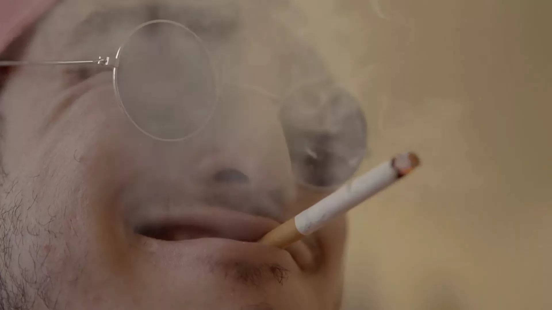 En mand med briller ryger en cigaret Wallpaper