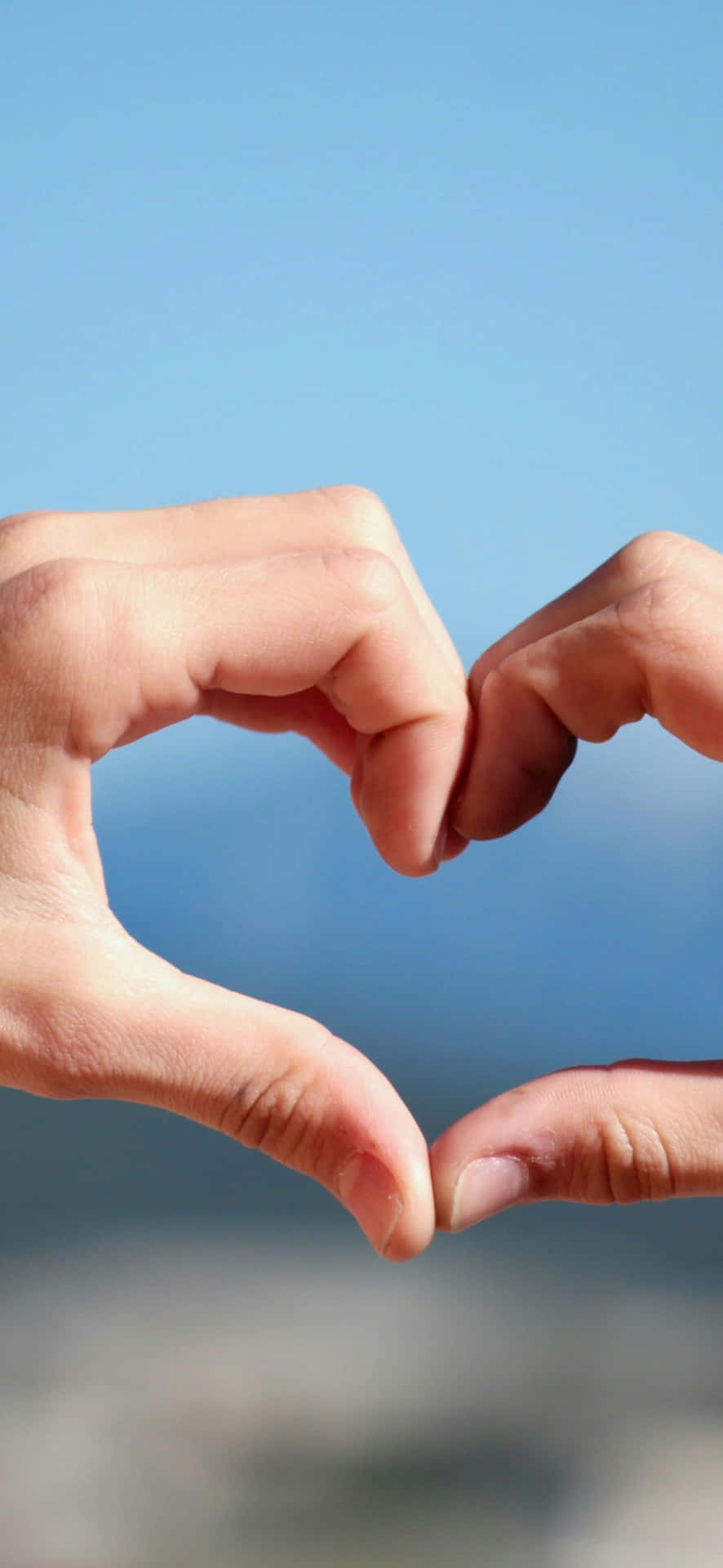 Finger Heart Gesture Against Blue Sky Wallpaper