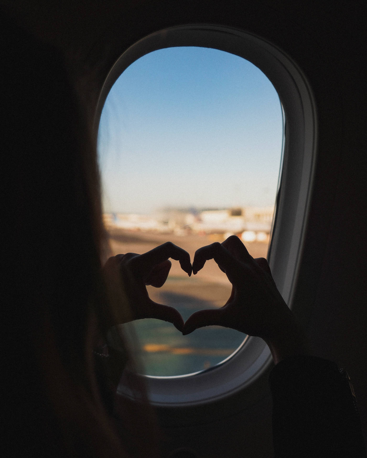 Corazóncon Los Dedos Durante Un Viaje En Avión. Fondo de pantalla