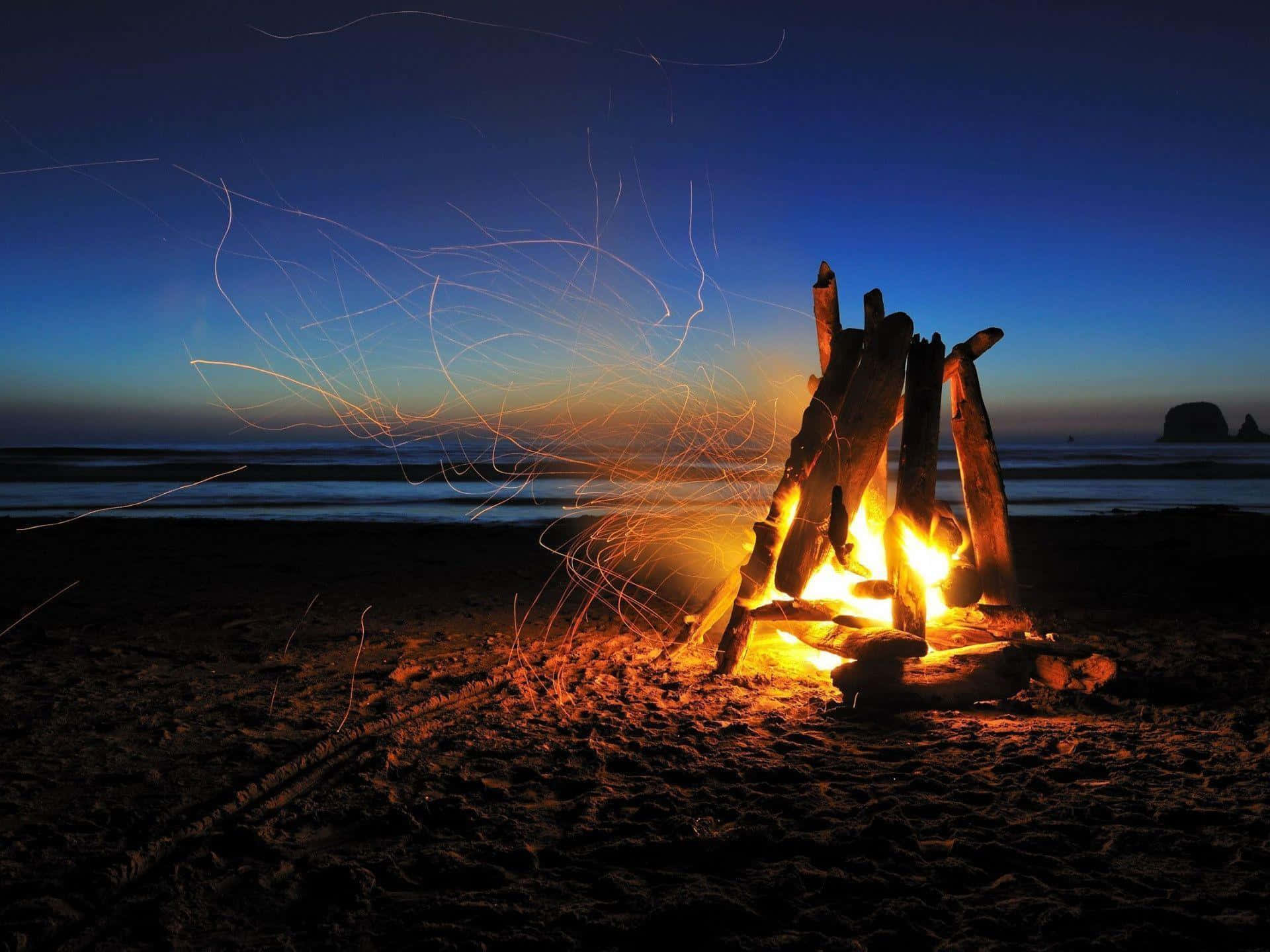 a campfire on the beach at night