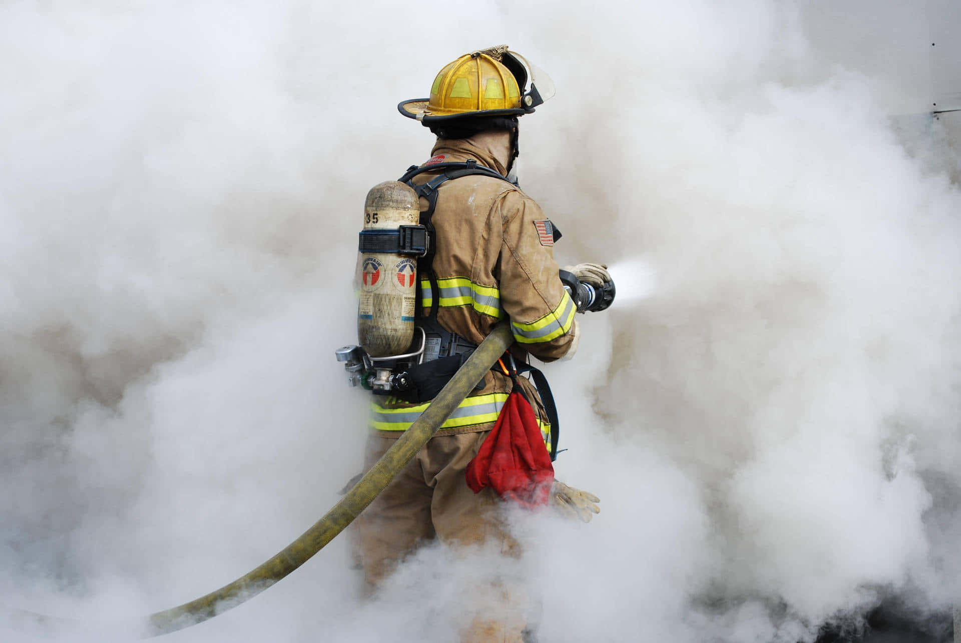 En brandmand sprøjter røg ud fra et bygning. Wallpaper