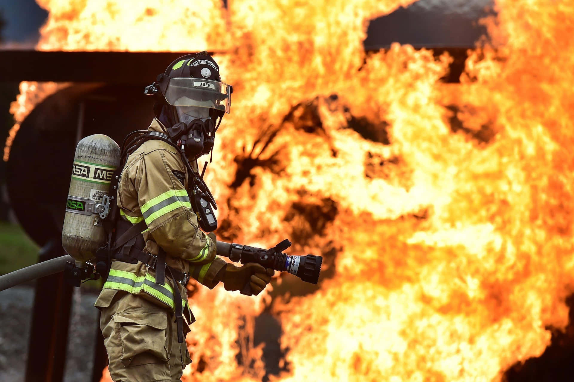 En brandmand står foran en stor ild Wallpaper