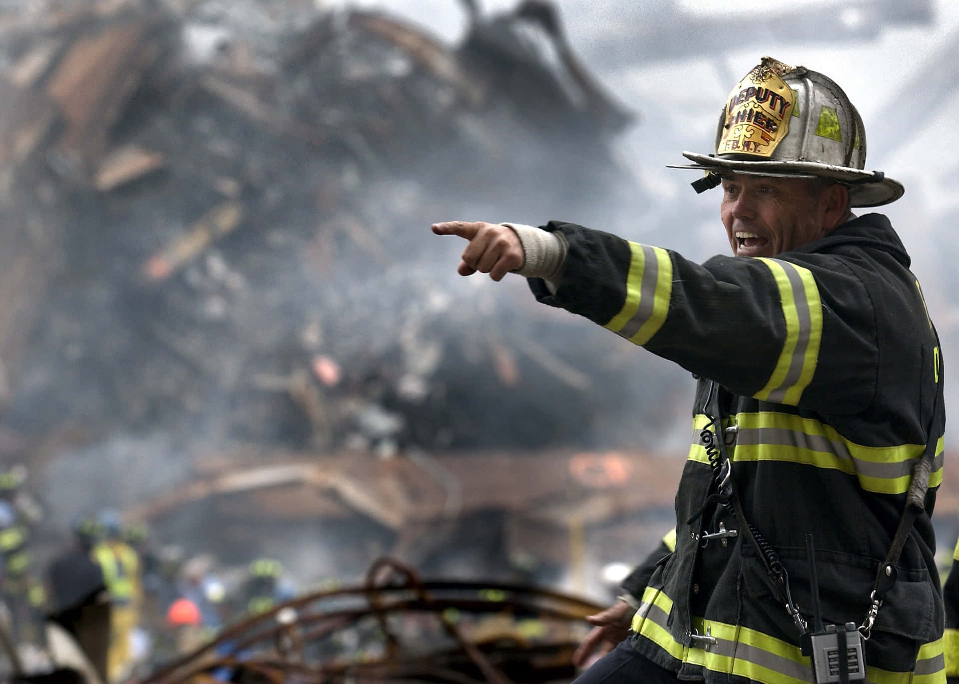 A Firefighter Pointing At A Pile Of Rubble Wallpaper