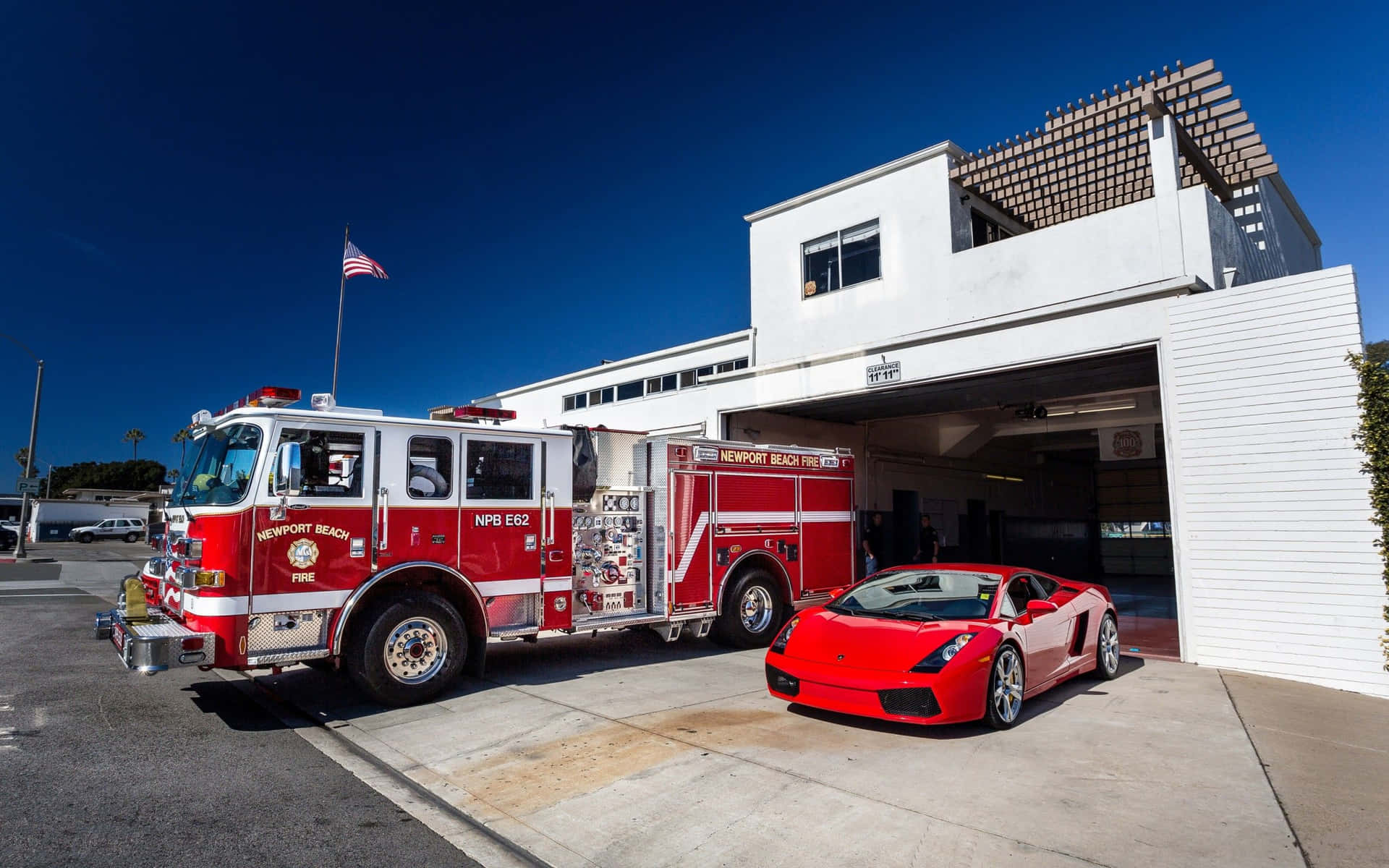 A Fire Truck And A Red Sports Car Parked In Front Of A Fire Station