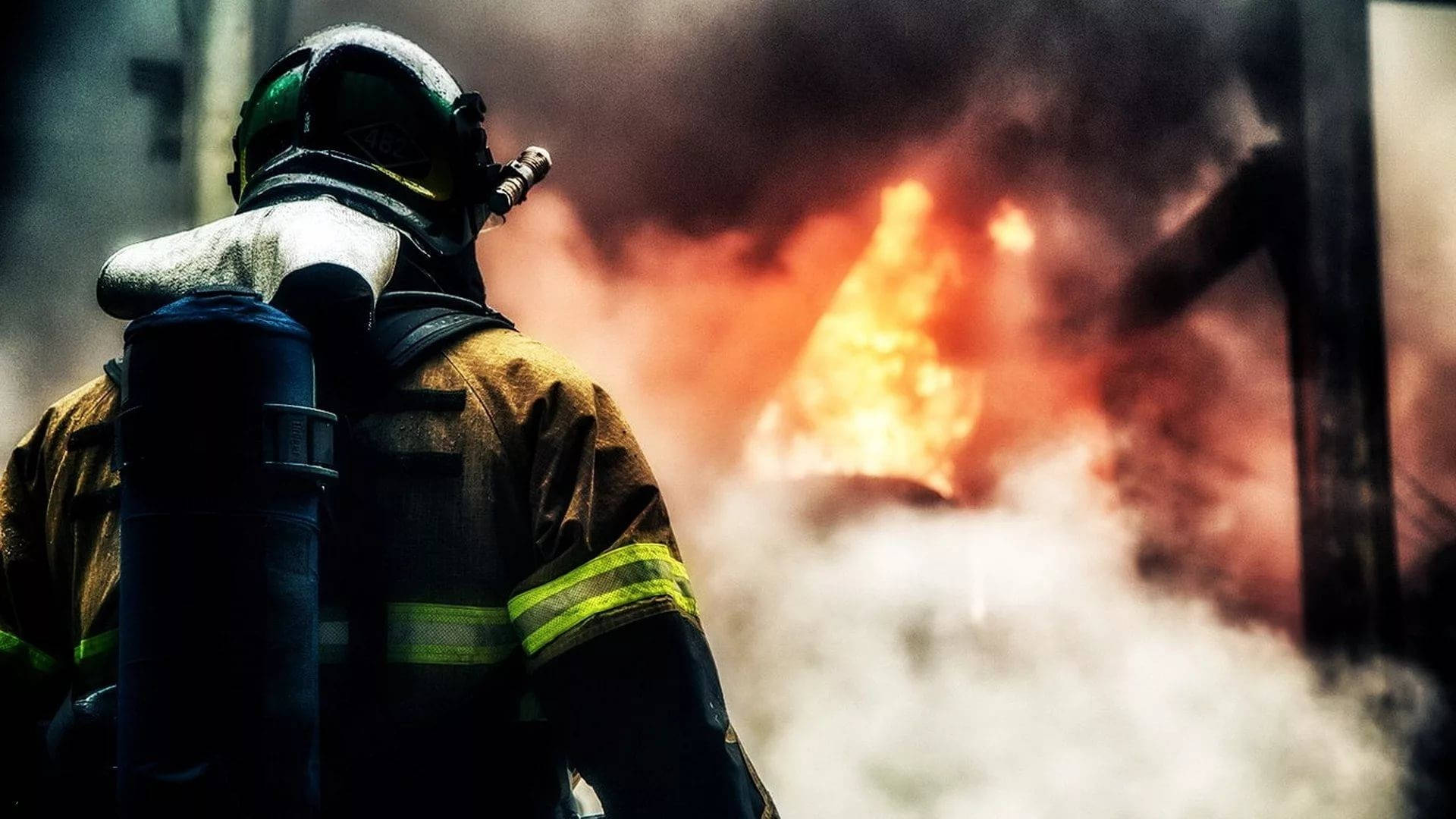 Firefighter Facing A Fiery Area Wallpaper