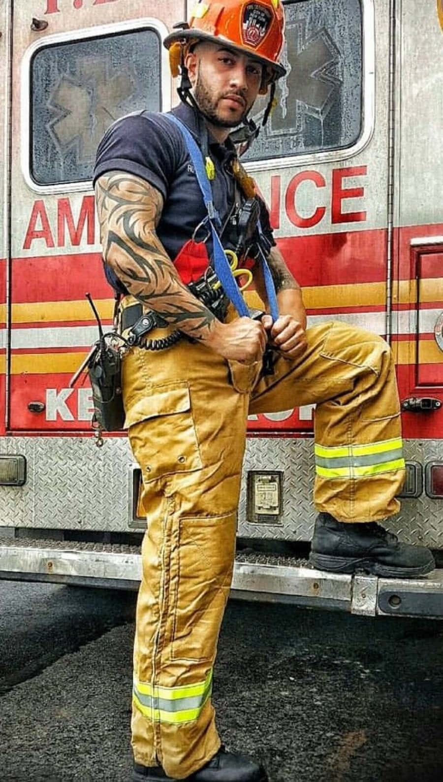 En mand i brandmandstøj, der støtter sig til en lastbil Wallpaper