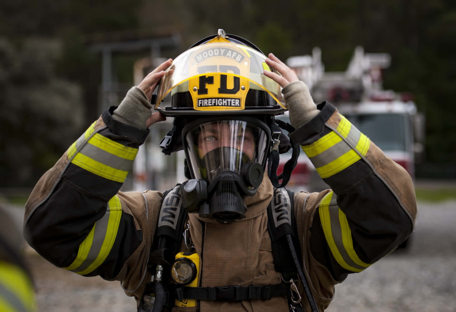 A Firefighter Is Putting On His Helmet