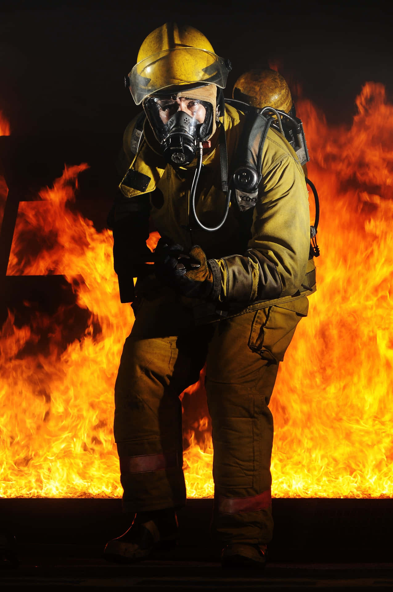 A Firefighter Is Kneeling In Front Of A Fire