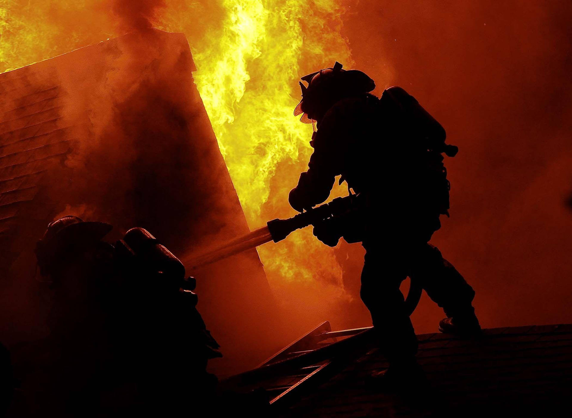 Firefighters On A Burning Roof Wallpaper